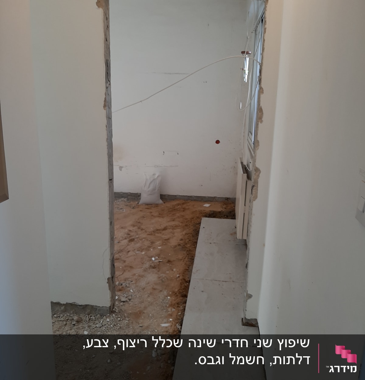 קיר פתוח עם חוטי חשמל, רצפה חשופה ושק מלט